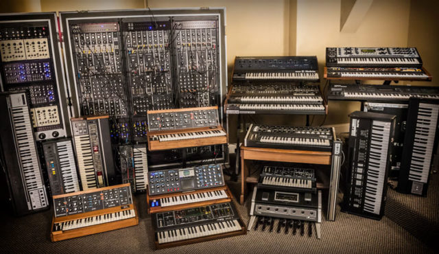 A room filled with syntronik synthesizers and keyboards.